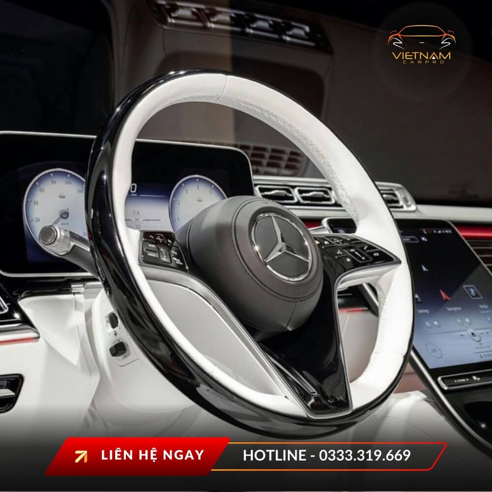 Cận cảnh vô-lăng xe Mercedes bọc da trắng – đen cùng bảng đồng hồ kỹ thuật số, điểm nhấn sang trọng trong khoang lái.